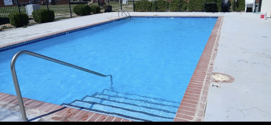 Rectangular pool after restoration, with clean brick coping and clear blue water